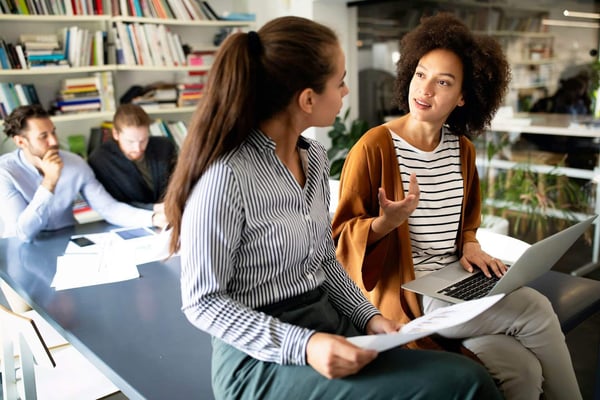 Two recruiters discussing 2025 recruitment trends